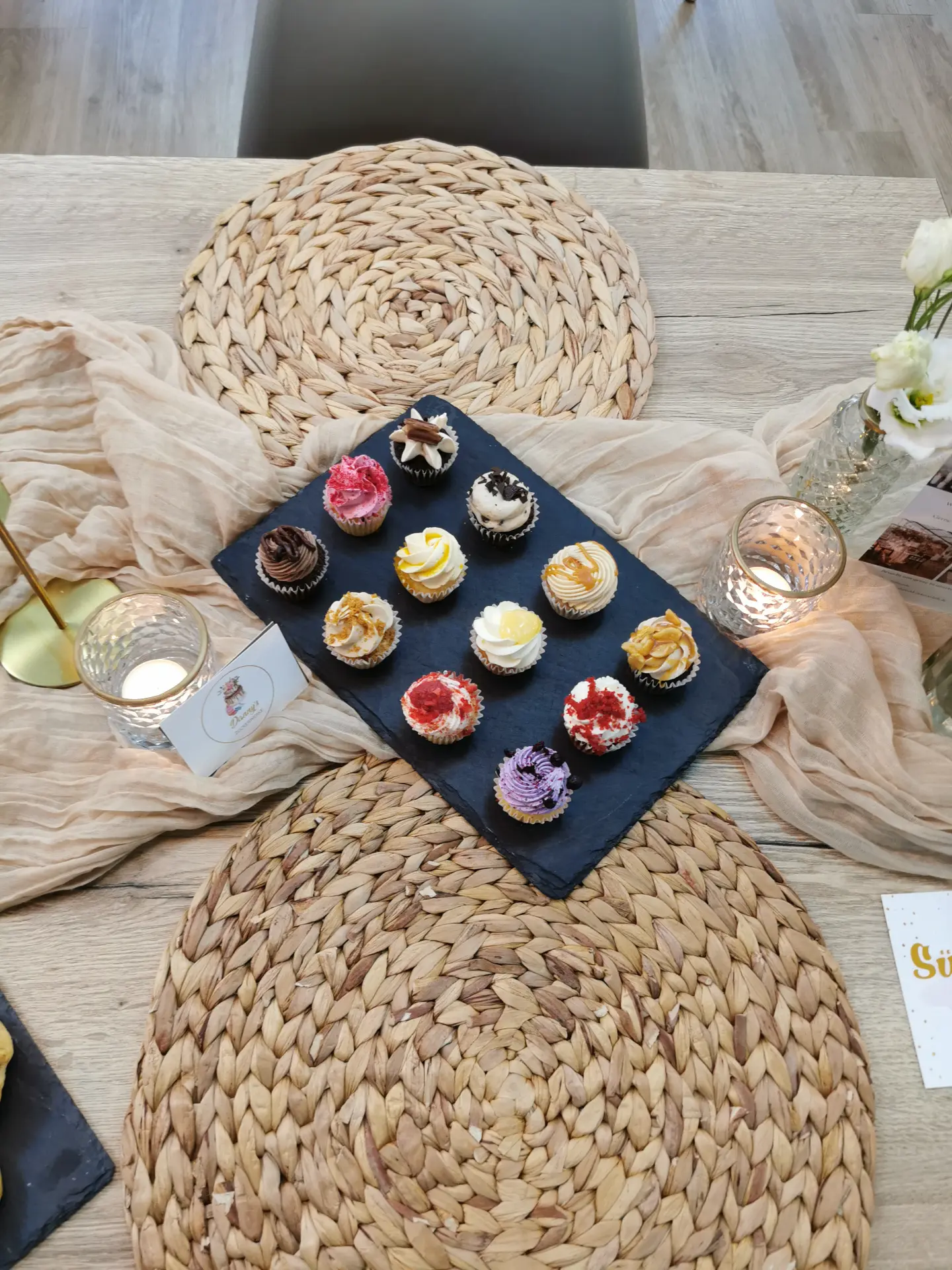 Zwölf Probier-Cupcakes aus der 12er Probierbox, auf einer Schieferplatte angerichtet